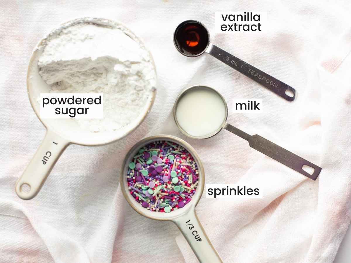 Ingredients needed to make the icing, including powdered sugar, sprinkles, vanilla, and milk.