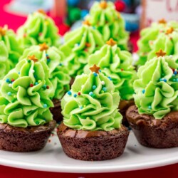 Christmas Tree Brownie Bites served on a white platter, with a red background.