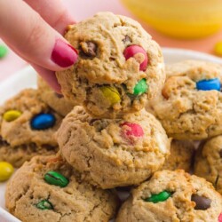 Taking a monster cookie from a plate of cookies