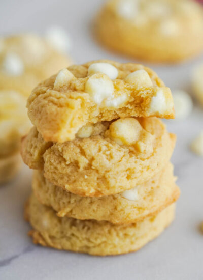 a stack of four banana pudding cookies with a bite missing from the top one.