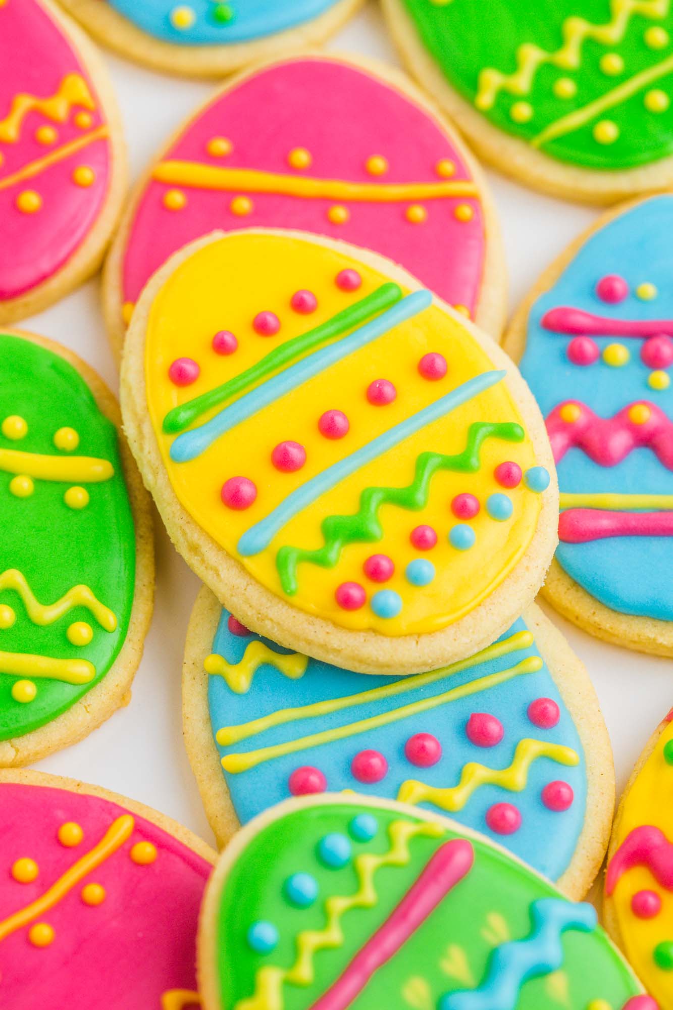 Egg shaped sugar cookies decorated with lines, dots, and squiggles in bright neon colors