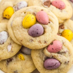a white plate filled with cookies topped with easter cadbury mini eggs.