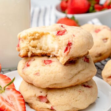 a small plate filled with three stacked cheesecake stuffed strawberry cookies.