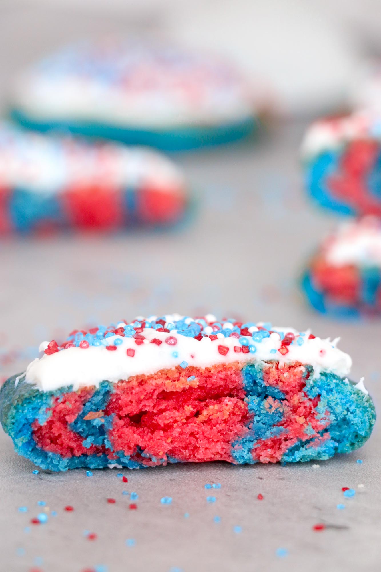 A 4th of july cookie with white frosting and sprinkles