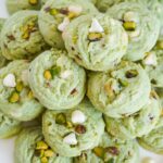 Pistachio pudding cookies stacked on a white plate