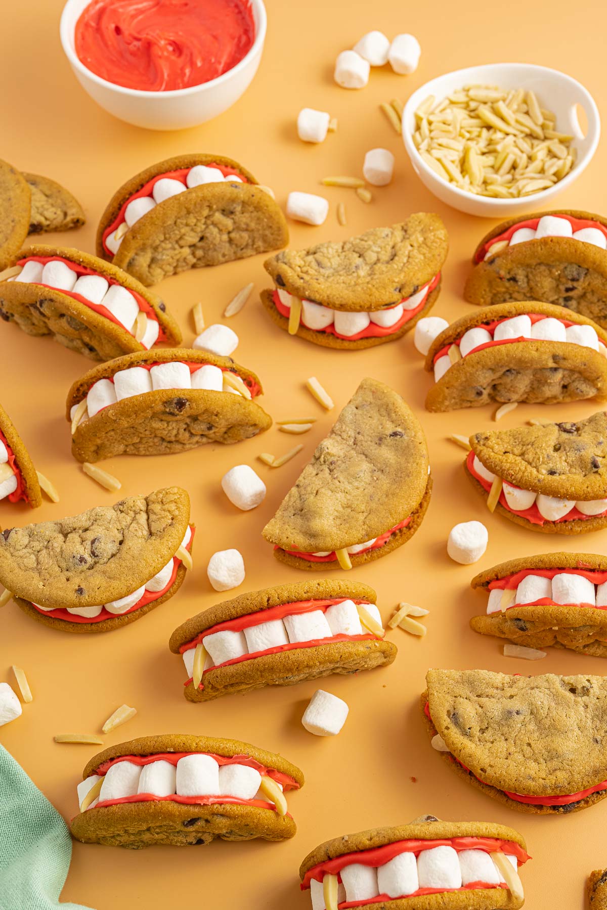 Dracula dentures cookies strewn about on an orange background.