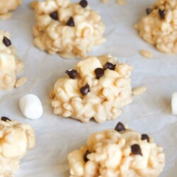 Avalanche cookies placed on parchment paper, and a small blue bowl in the background.