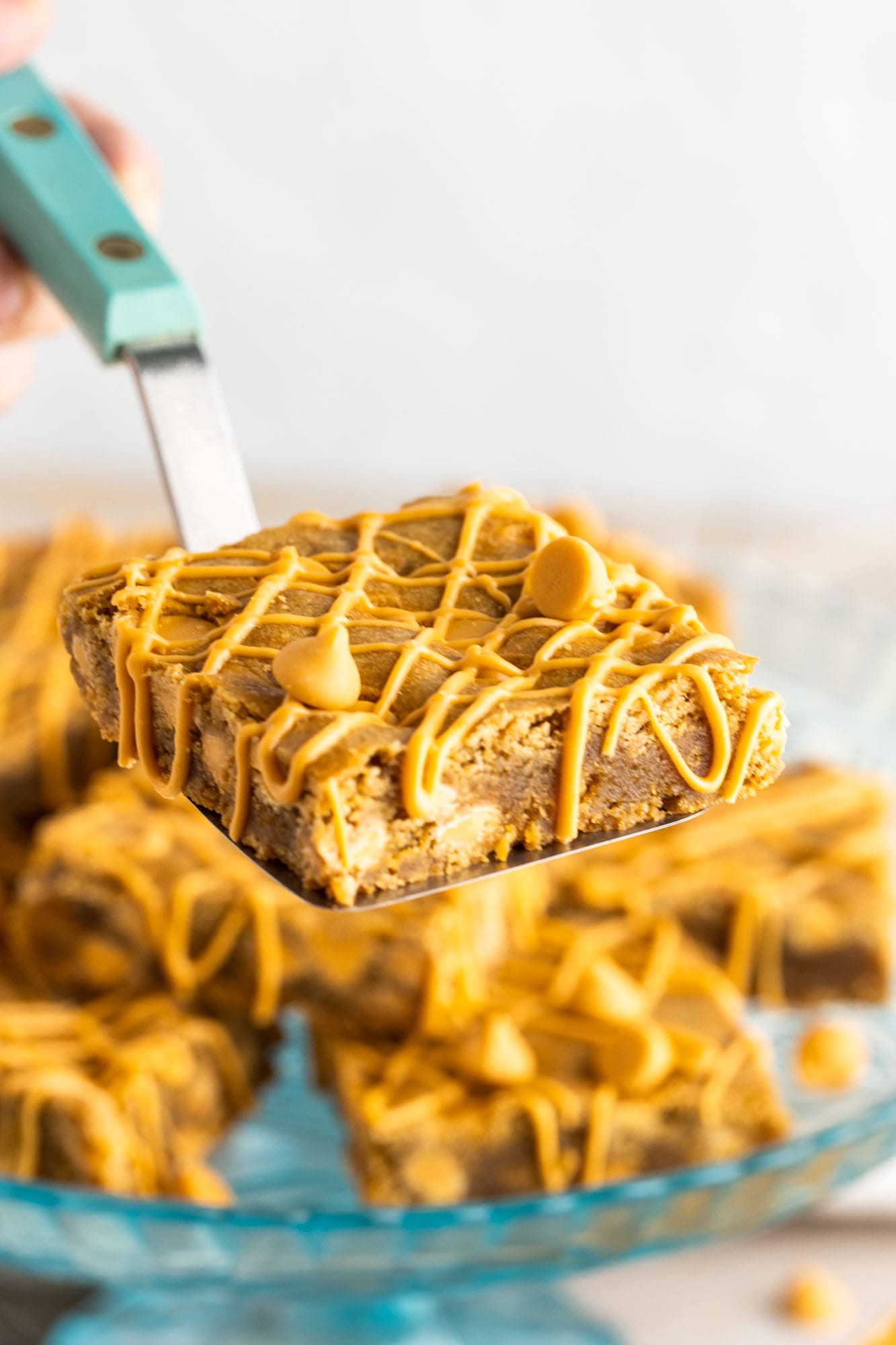 a butterscotch blondie held up with a spatula