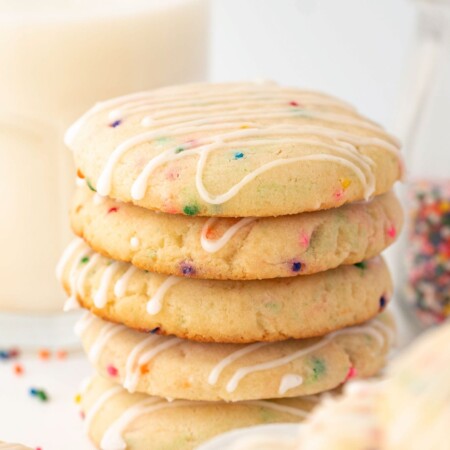 stack of cookies with a glass of milk in the background