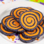 black and orange swirled cookies on a white plate