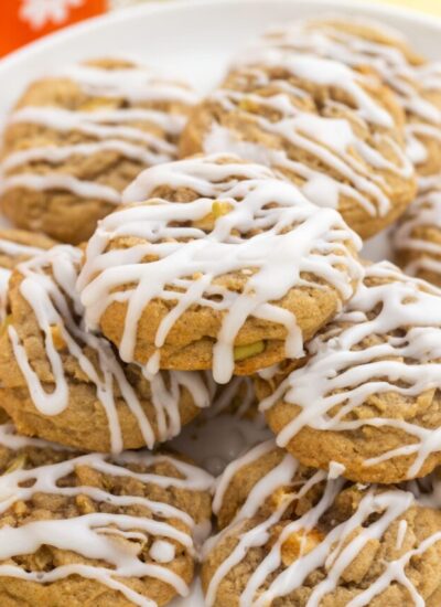 a platter of apple cookies with white drizzled frosting.