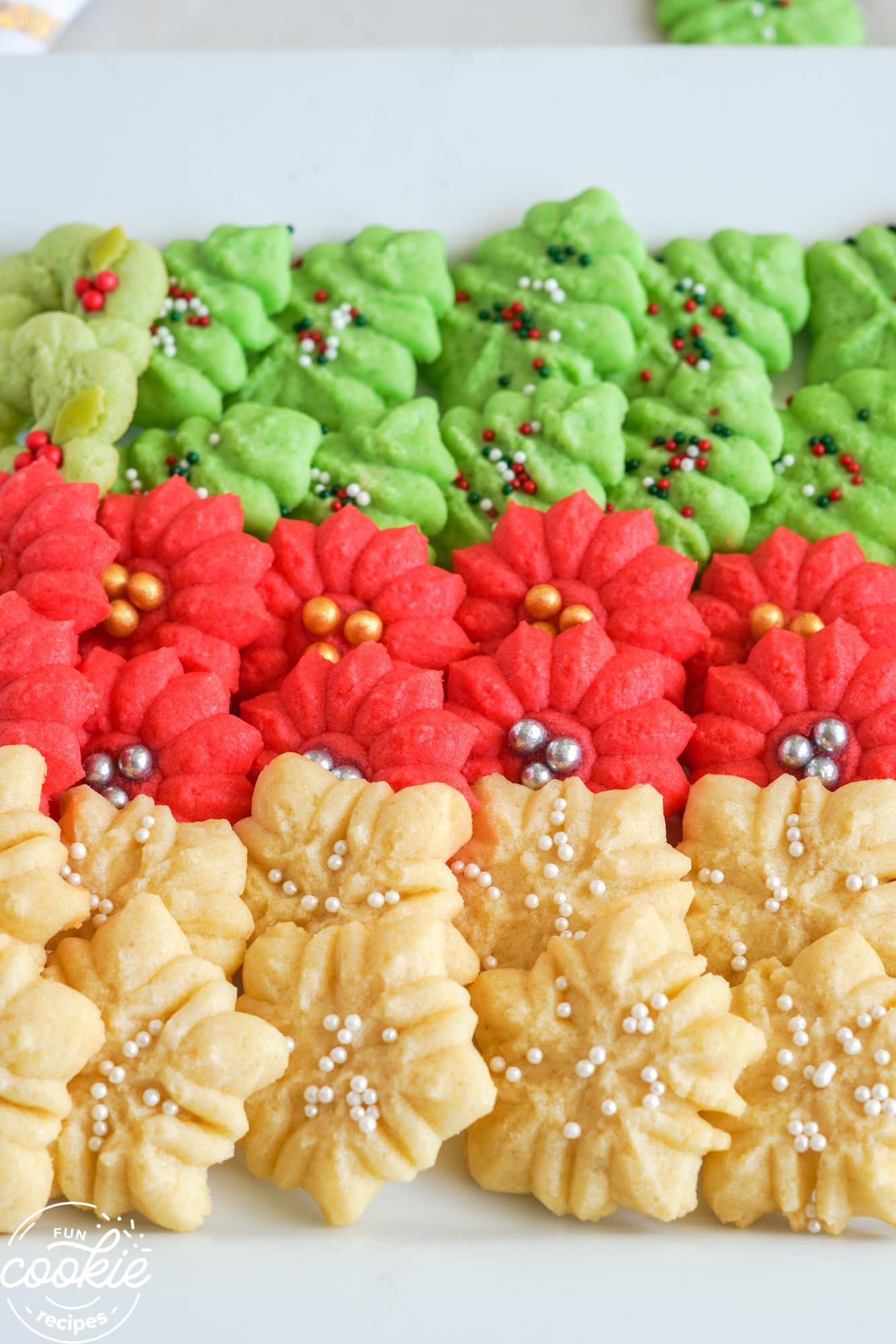 Rows of holiday spritz cookies on a white plate