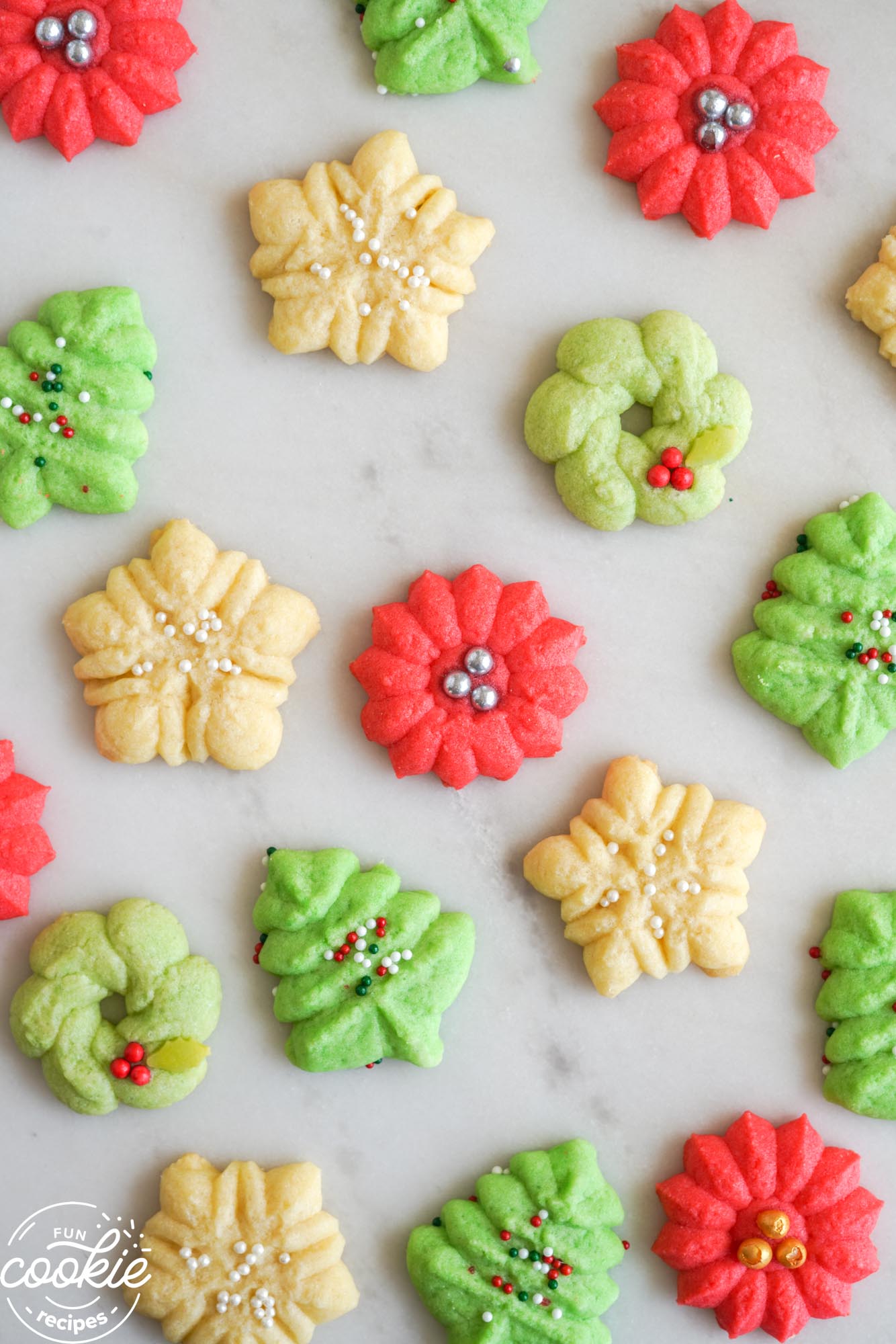 Small spritz cookies on a marble countertop, an overhead shot.