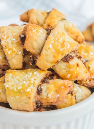 a bowl filled with rugelach cookies coated in coarse sugar.