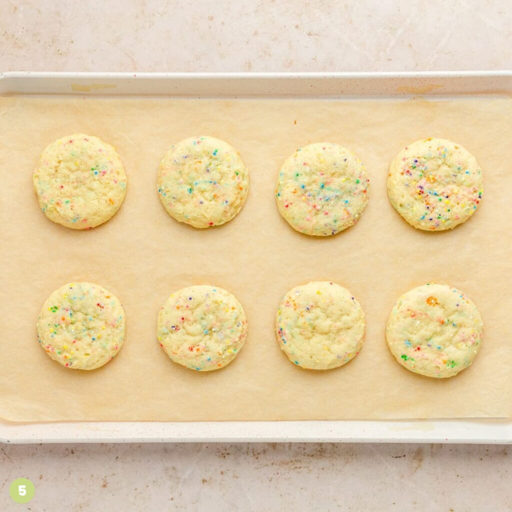 Sprinkle sugar cookies on a baking sheet lined with parchment paper.