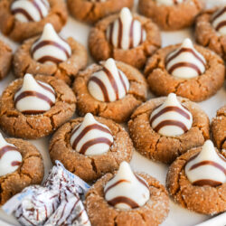 Gingerbread kiss cookies on a white cake stand