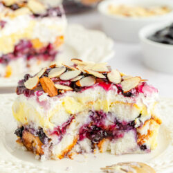 A slice of blueberry heaven on earth cake, plated with a fork, showing a bite shot