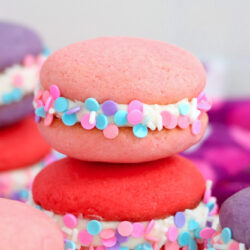 a red sprinkled whoopie pie underneath a light pink one.