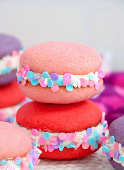 a red sprinkled whoopie pie underneath a light pink one.
