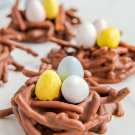 Birds nest cookies made with chinese noodles and chocolate, holding cadbury mini eggs.