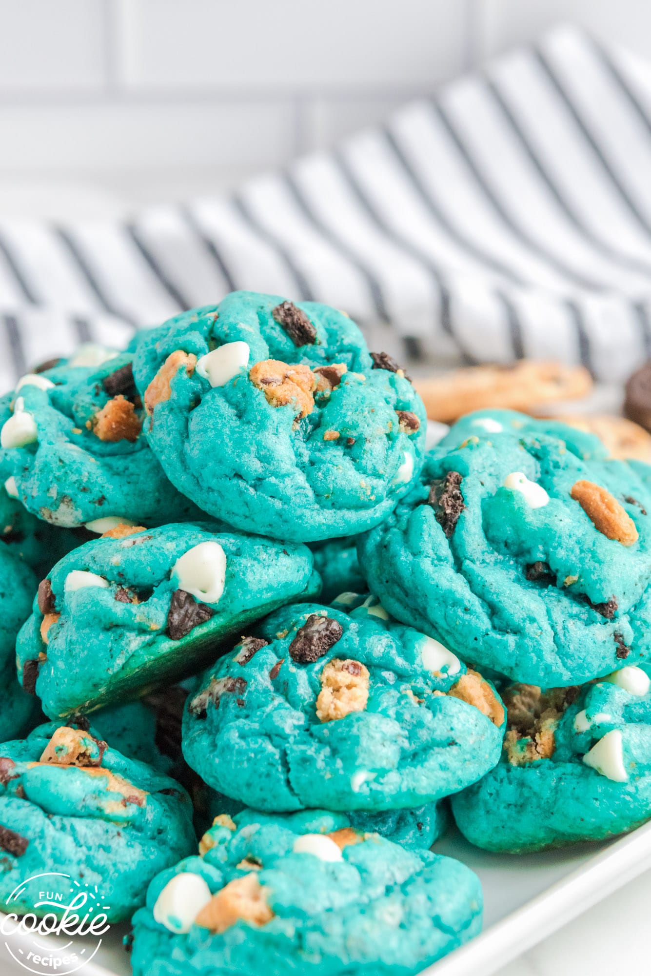a pile of blue cookie monster cookies on a white tray.