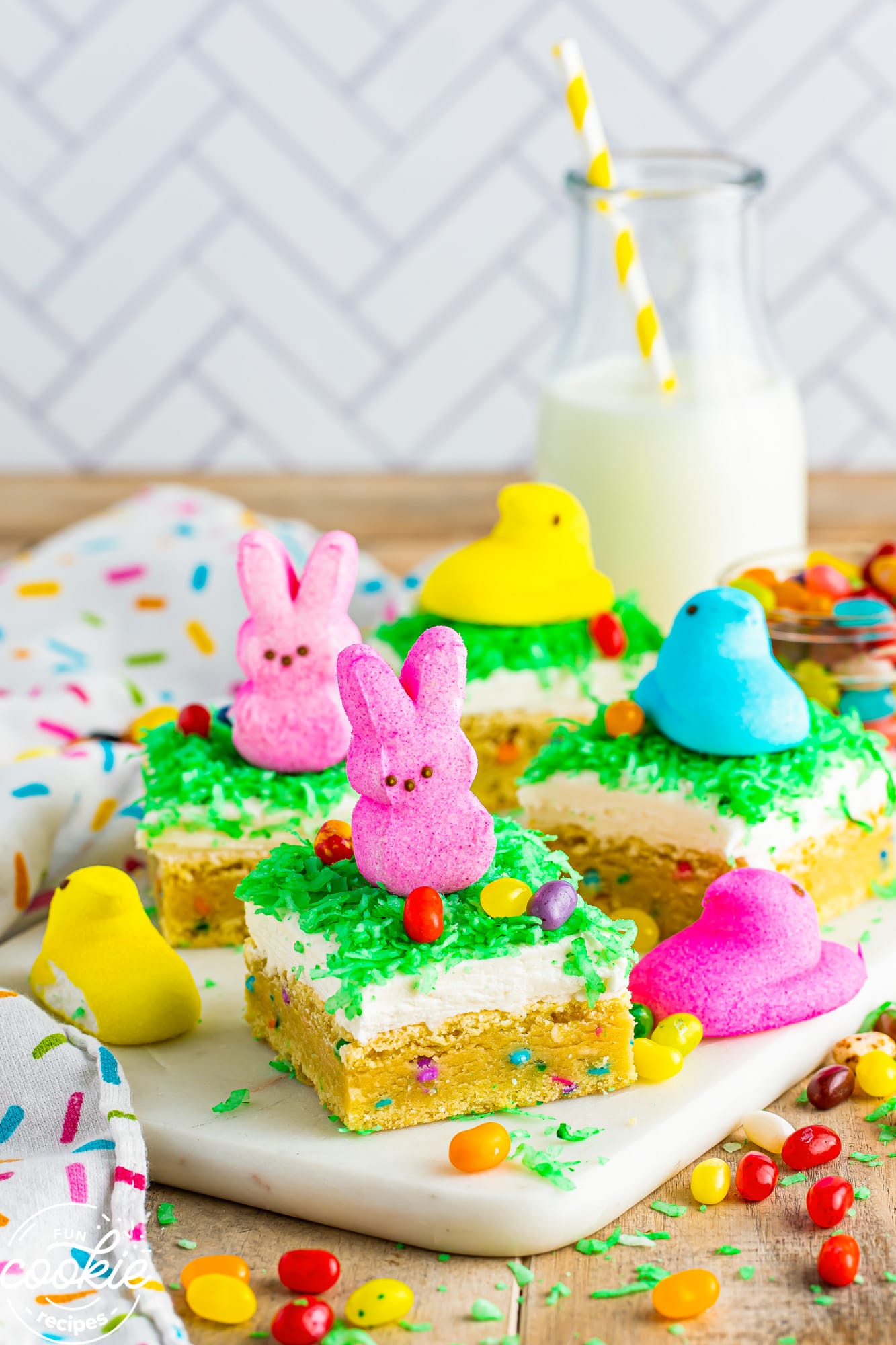 easter sugar cookie bars on a platter, decorated with peeps and jelly beans.