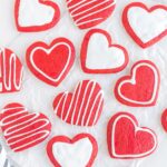 Red velvet heart cookies, decorated with simple white icing designs.
