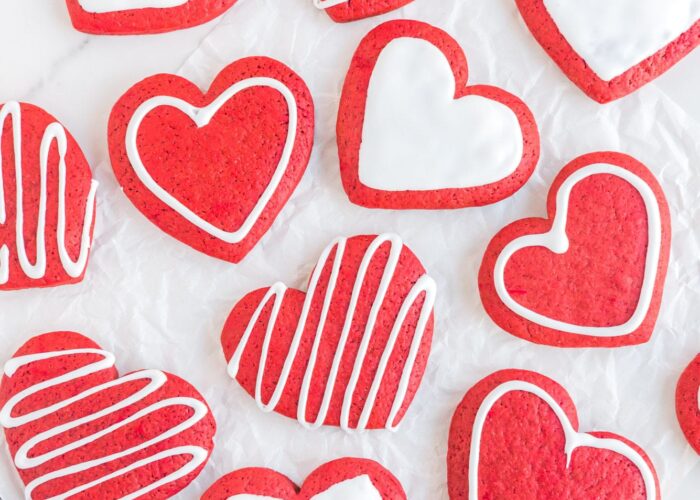Red velvet heart cookies, decorated with simple white icing designs.
