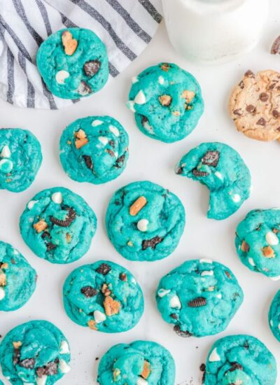 blue cookie monster cookies arranged on a counter.