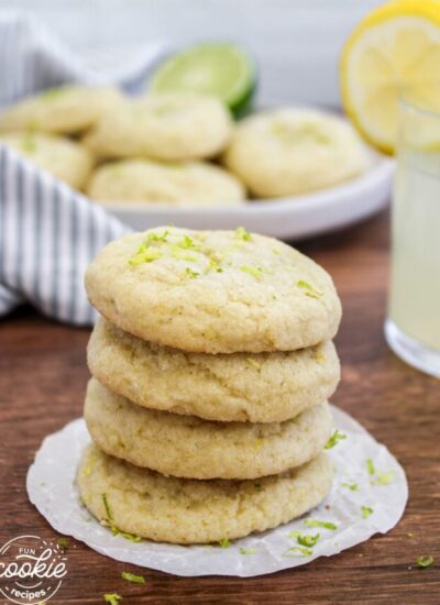 4 lime cookies stacked on a wooden board
