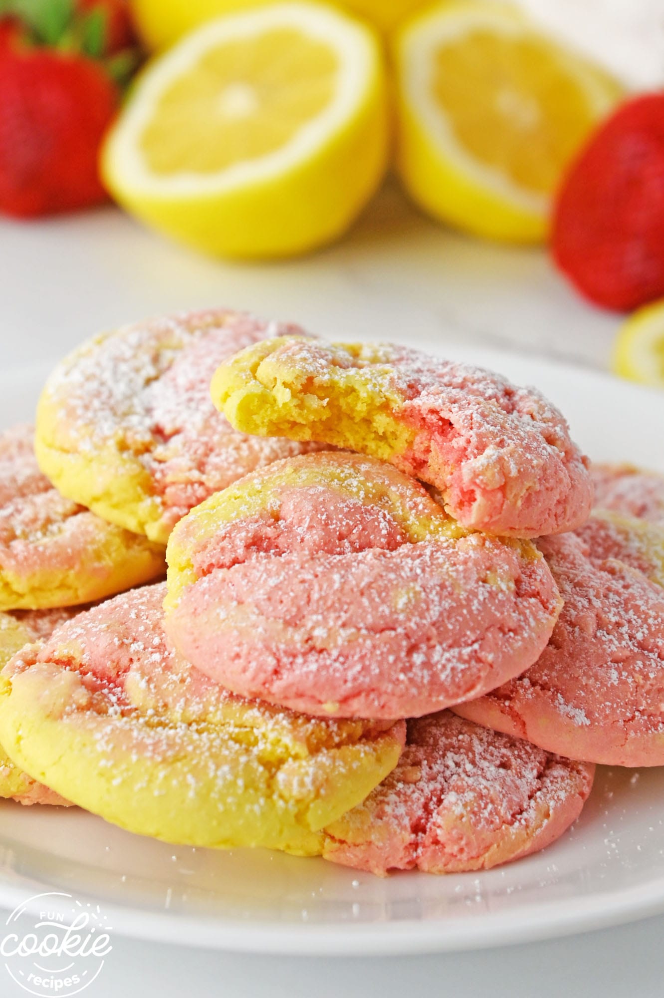 Cake mix strawberry lemonade cookies on a white plate, showing a bite shot.