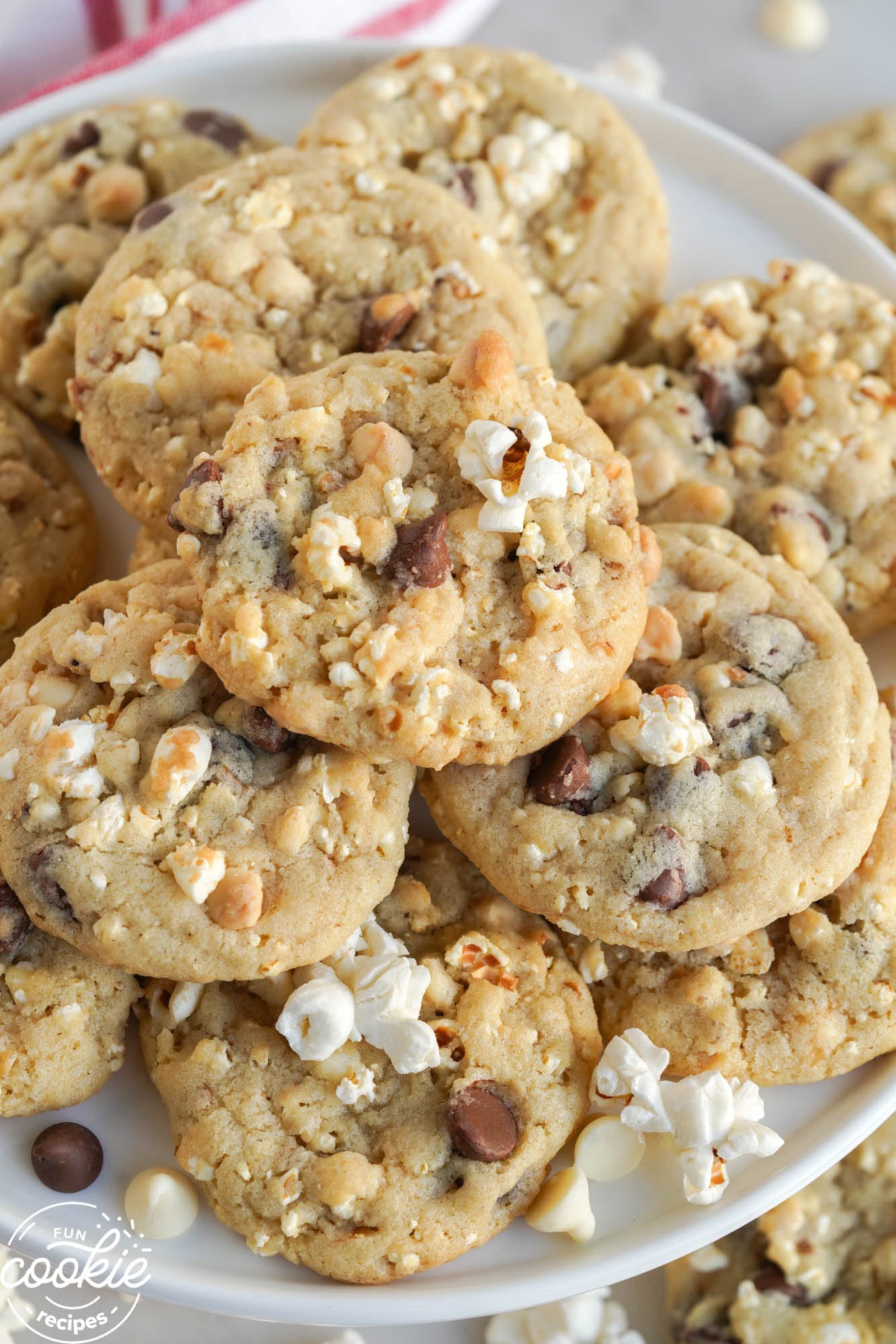 A platter filled with chocolate chip cookies with popcorn in them.