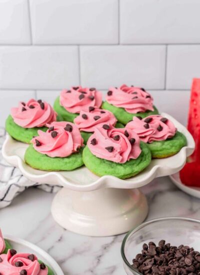 A cake pedestal holding 7 watermelon cookies.