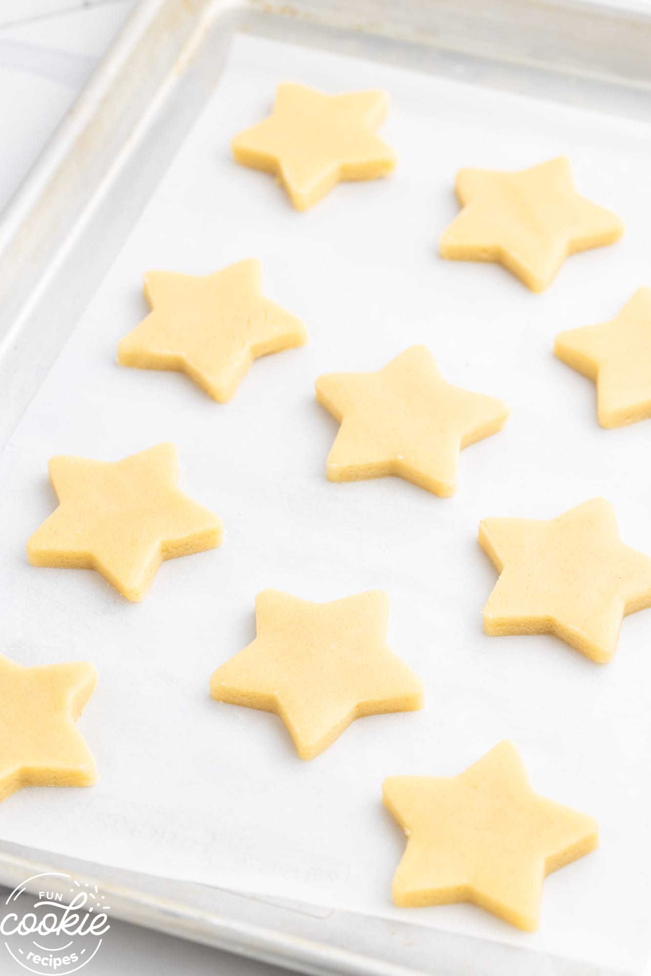 Star shaped sugar cookie dough on a baking sheet before baking