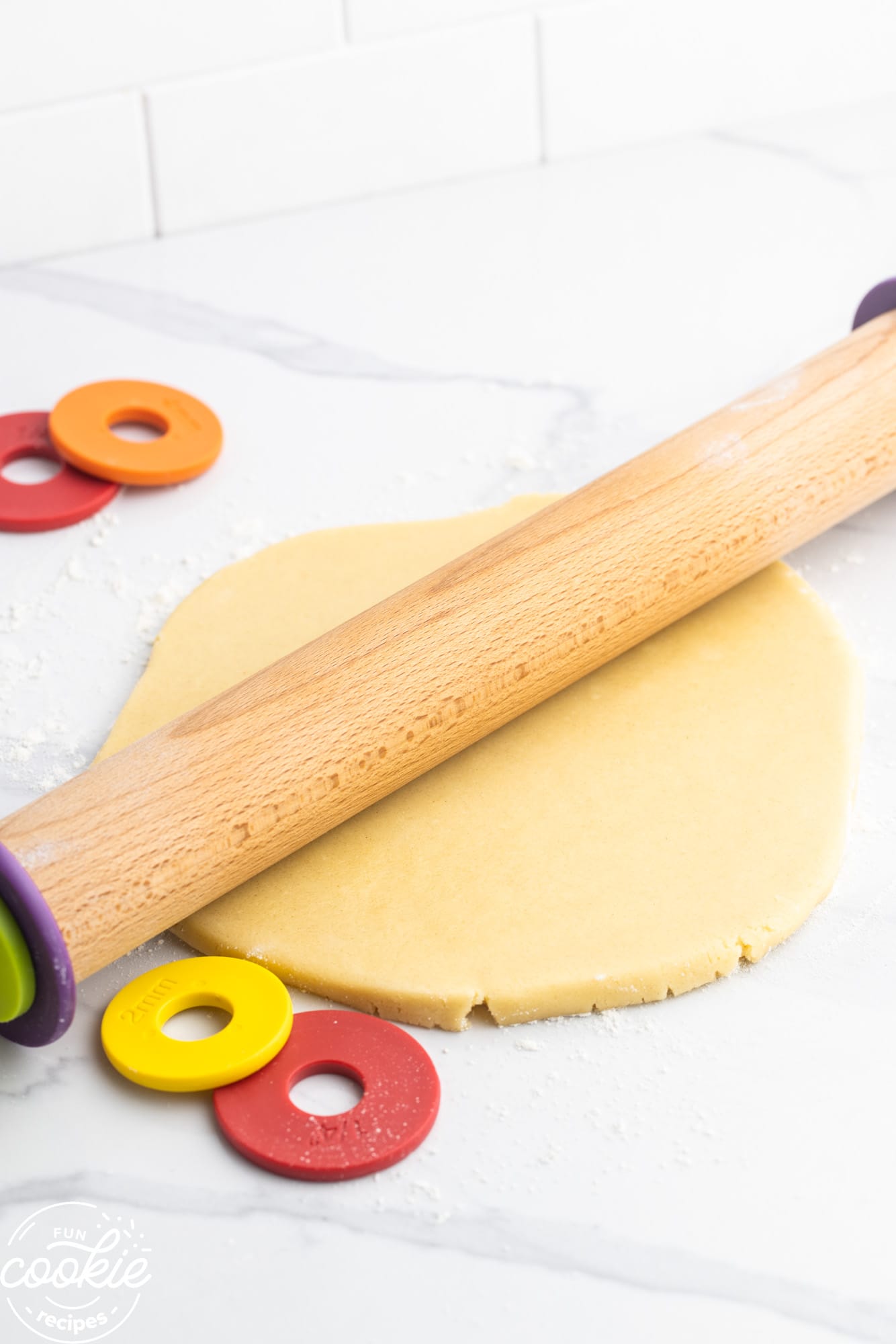 Rolling out sugar cookie dough using an adjustable rolling pin