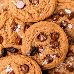 warm brown cookies with chocolate chips and flaky sea salt. Whole coffee beans are on top.