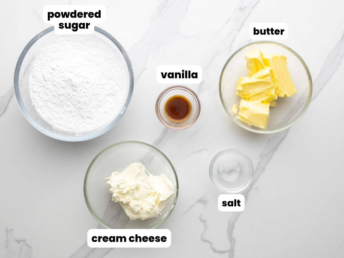 Ingredients needed to make cream cheese frosting including butter, cream cheese, powdered sugar, vanilla, and salt.