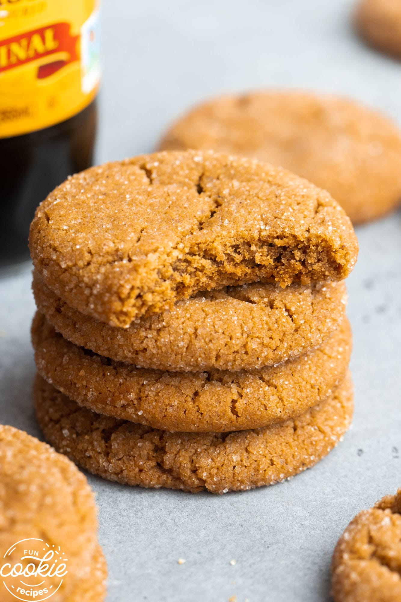 Four stacked cookies of molasses cookies showing a bite shot on the top one