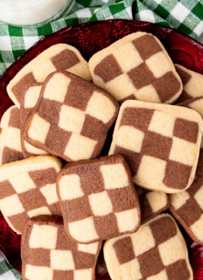 a pile of chocolate checkerboard cookies on a red platter.