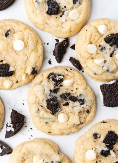 cookies with white chocolate chips and crushed oreos, on a white countertop.