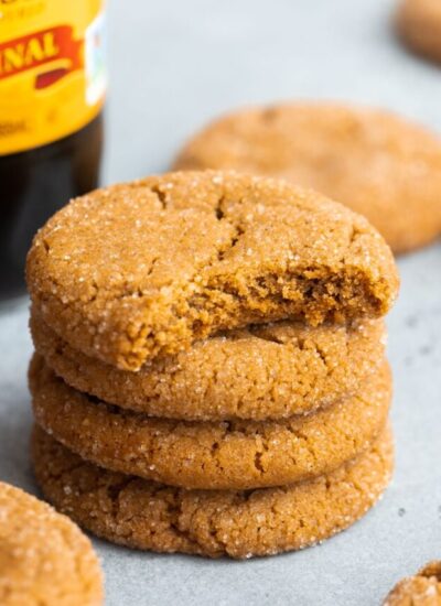 Four stacked cookies of molasses cookies showing a bite shot on the top one