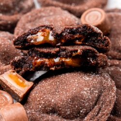 Rolo stuffed cookies. One has been browken in half to show the gooey caramel inside.