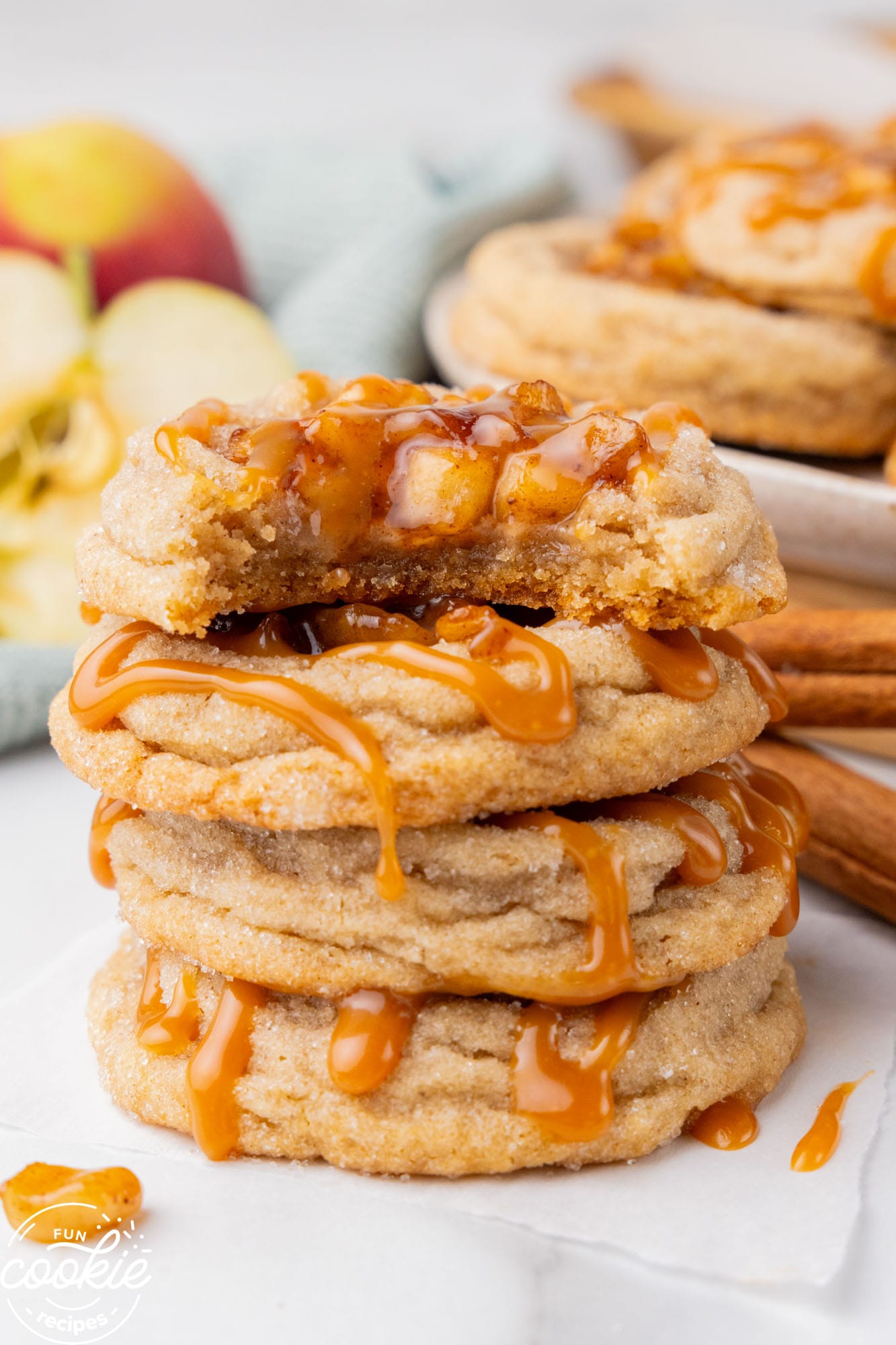 soft apple pie cookies in a stack. the top cookie has a bite taken.
