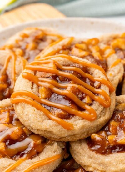 apple pie cookies with apple filling and caramel drizzled on top.