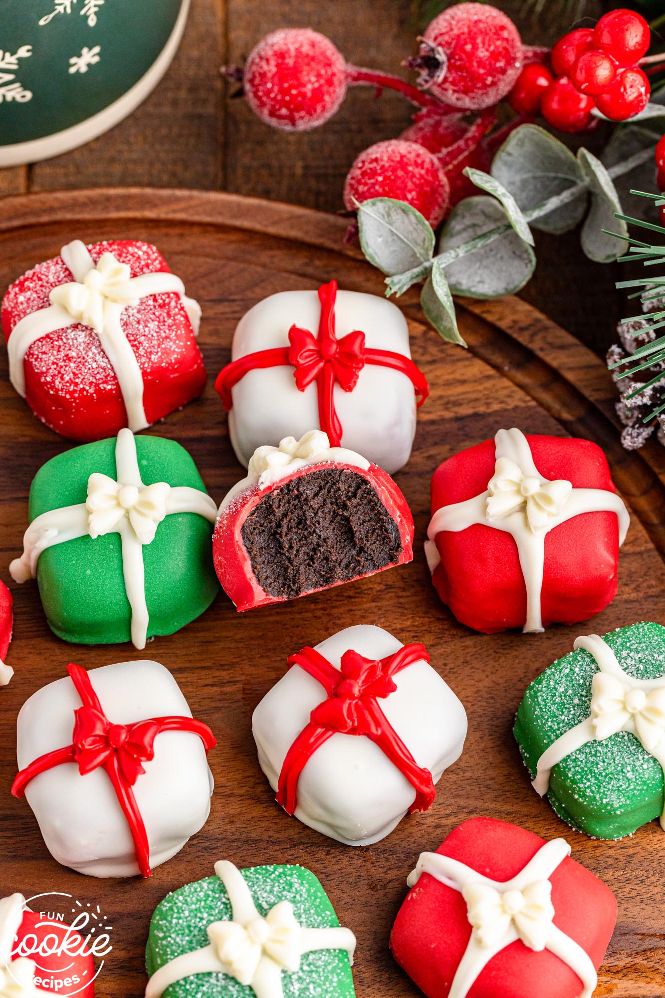 Christmas Present Oreo Truffles shown on a wooden tray with a bite shot