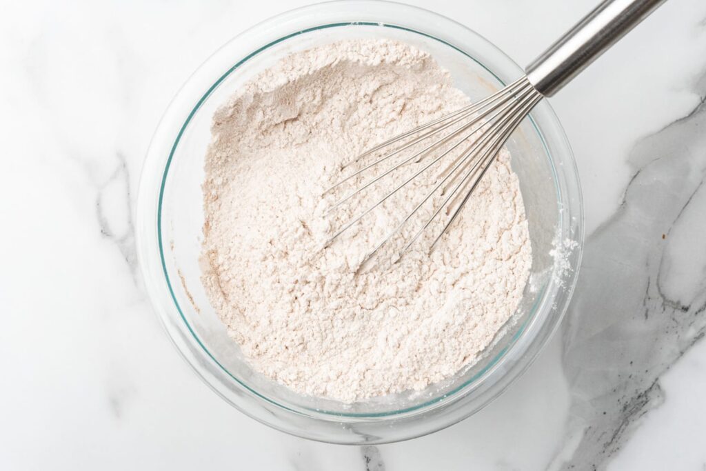 mixing dry ingredients for cookies in a bowl with a whisk