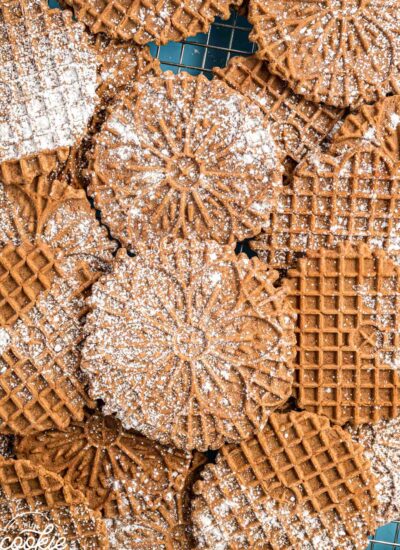Overhead shot of chocolate pizzelle cookies sprinkled with powdered sugar