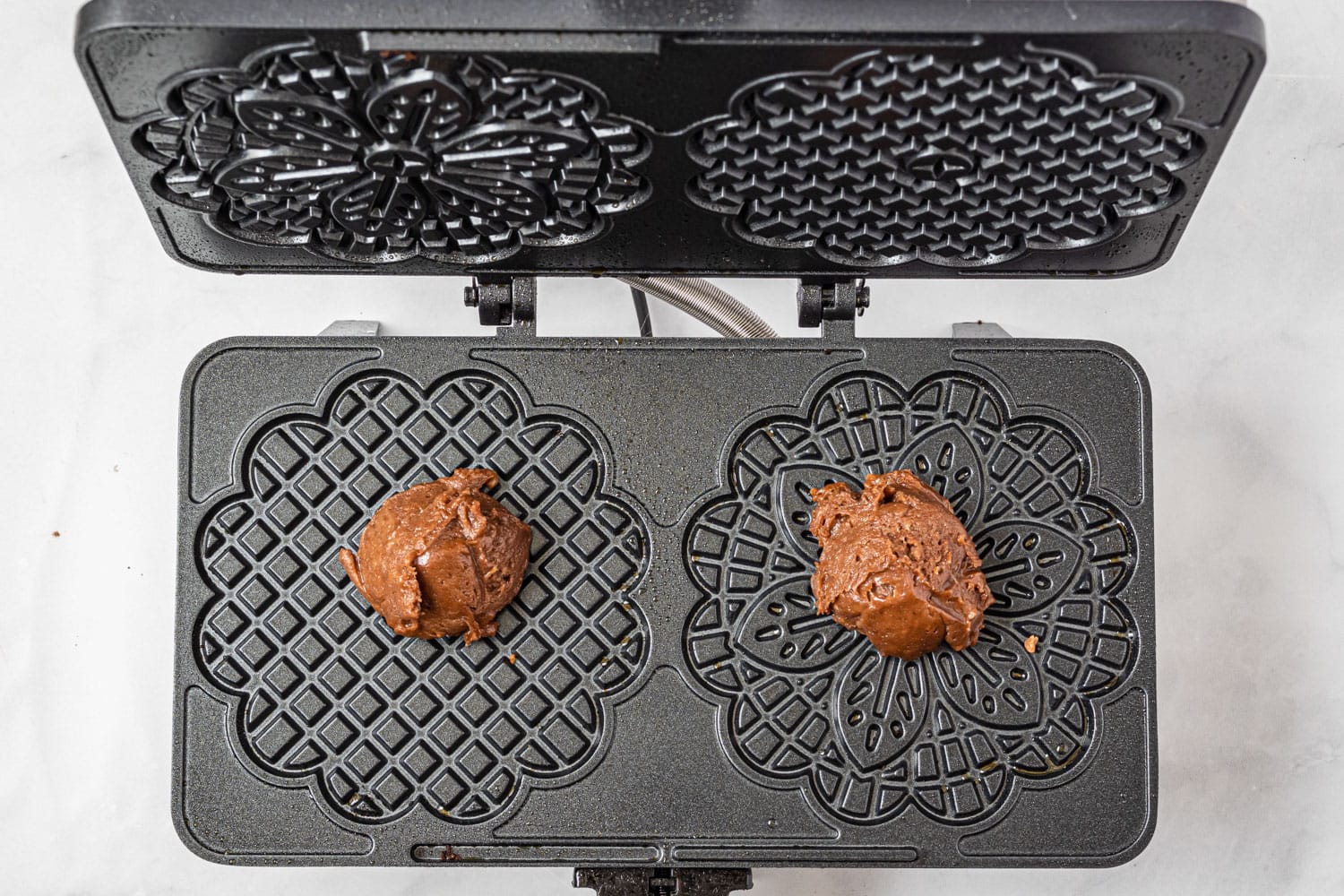Chocolate pizzelle batter in a pizzelle iron