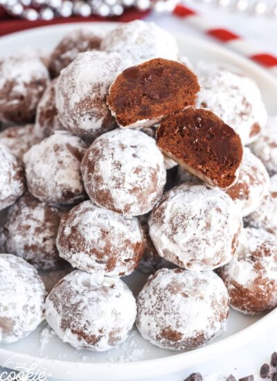 Chocolate Snowball Cookies stacked on a white plate