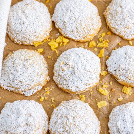 Potato chip cookies sprinkled with powdered sugar put in rows on parchment paper